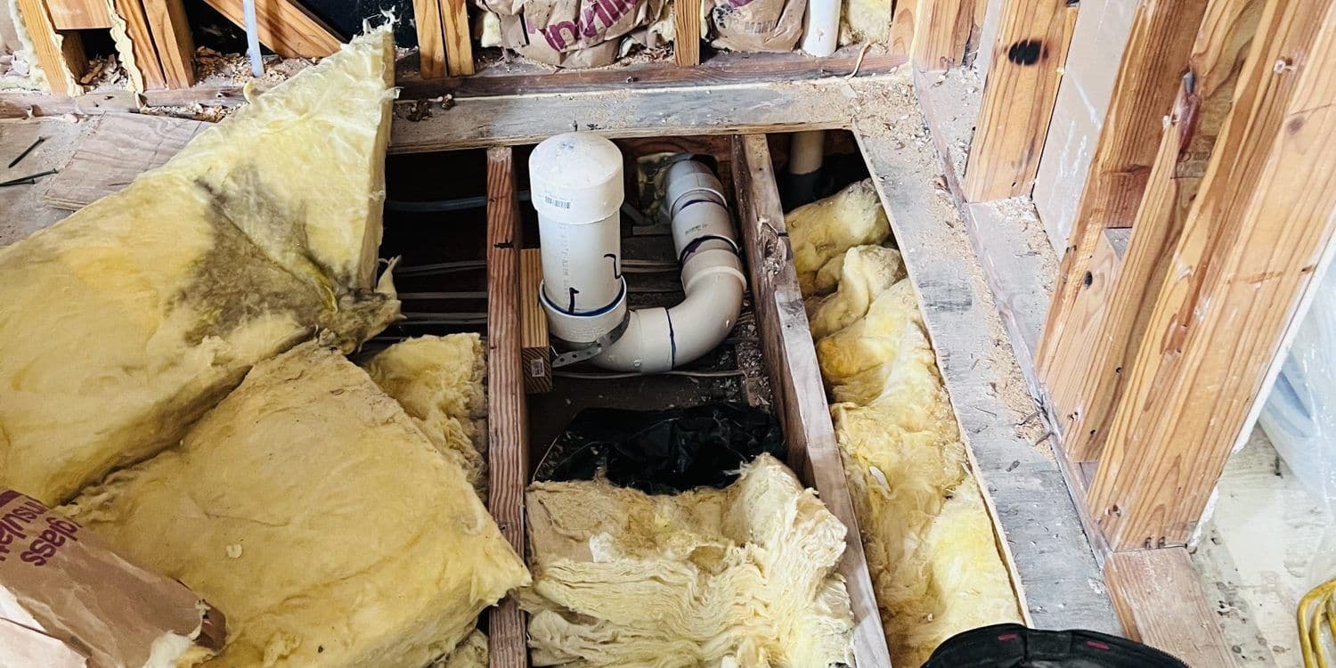 Floor opened up to reach the drain line under a house